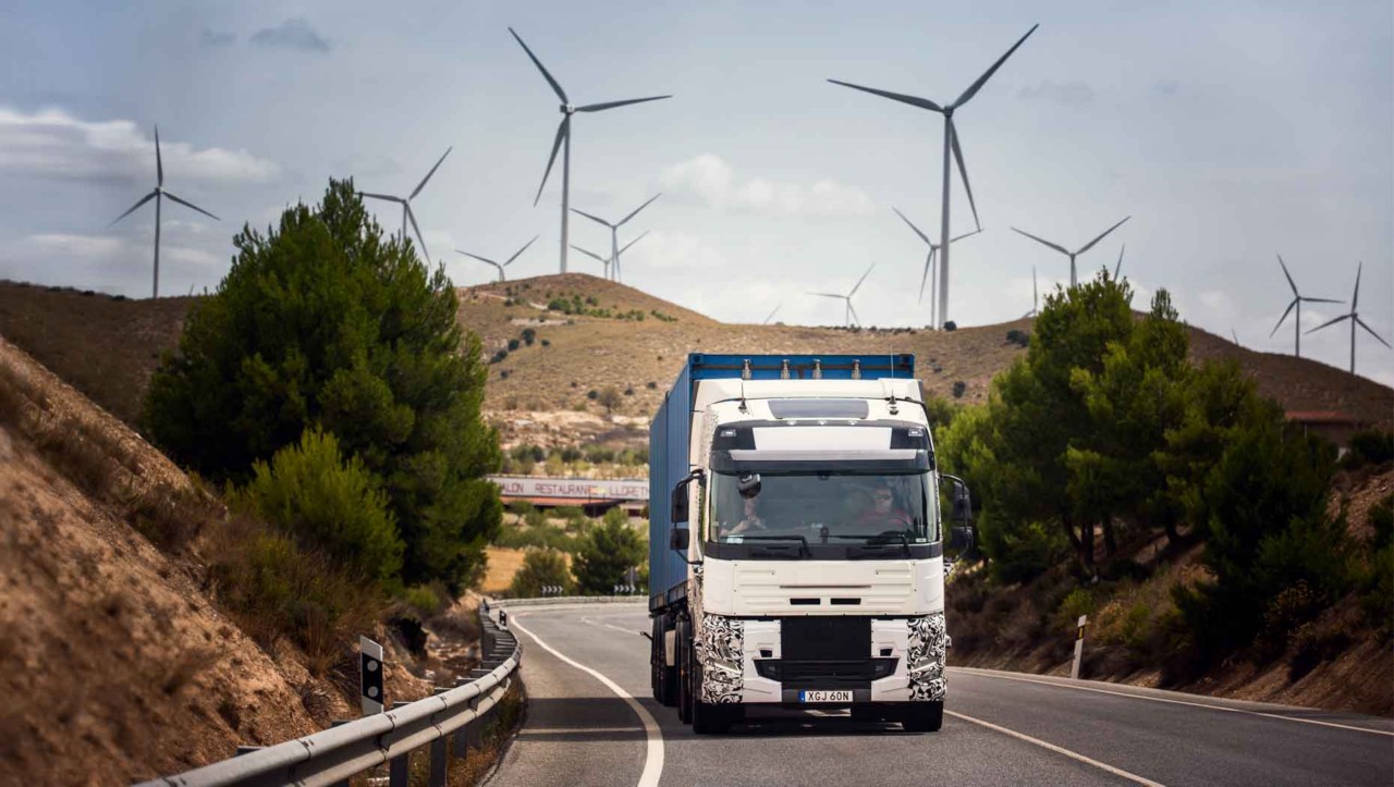 Een testtruck onderweg in Spanje met windturbines op de achtergrond